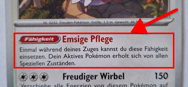 Pokémon-Karte mit der Fähigkeit „Emsige Pflege“, die es erlaubt, das aktive Pokémon von speziellen Zuständen zu heilen. Eine rote Markierung hebt diesen Bereich hervor.